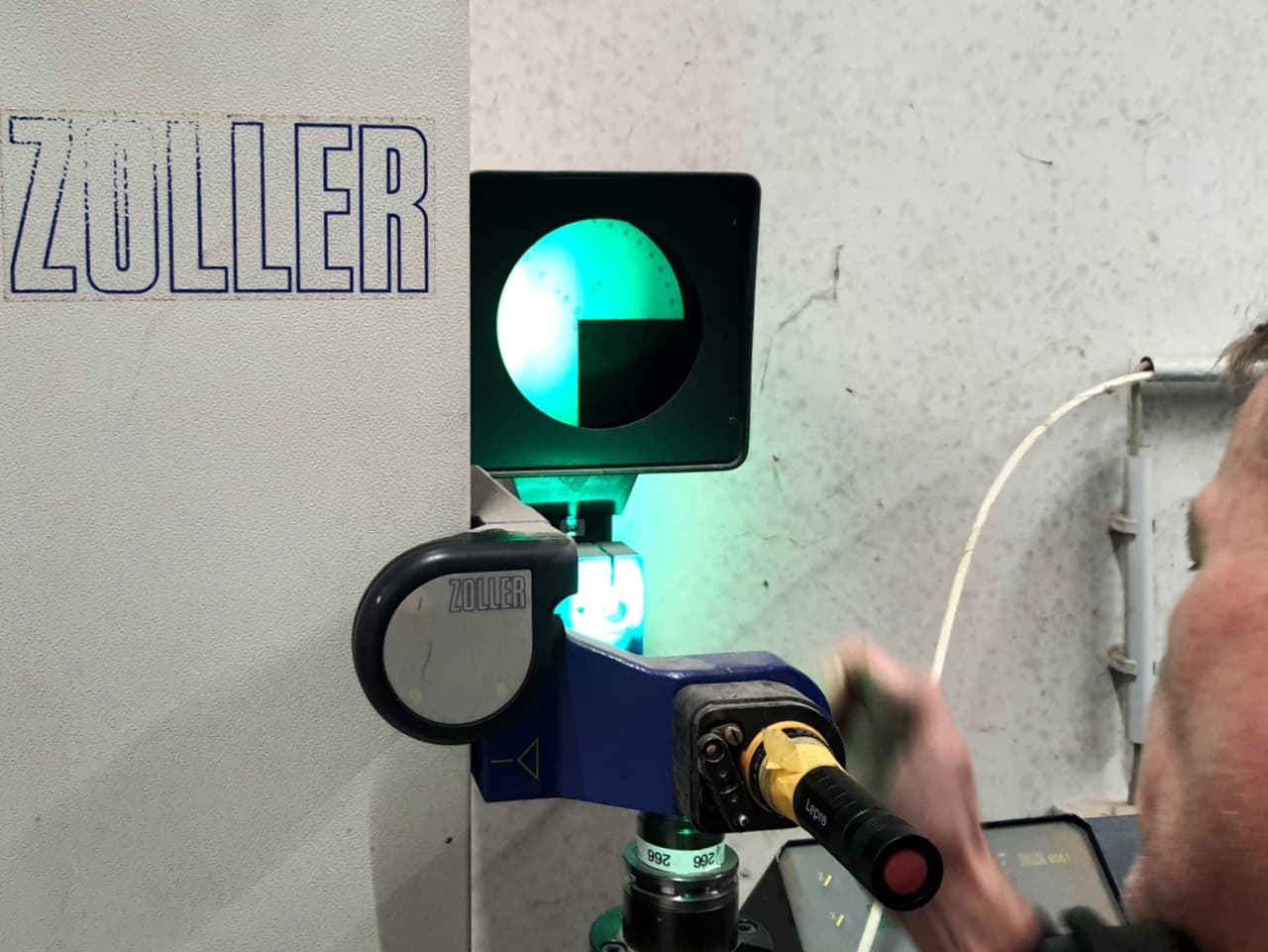 Mitarbeiter vermisst ein Werkzeug an einem Zoller-Messgerät, auf dem Monitor ist das Messbild zu sehen.