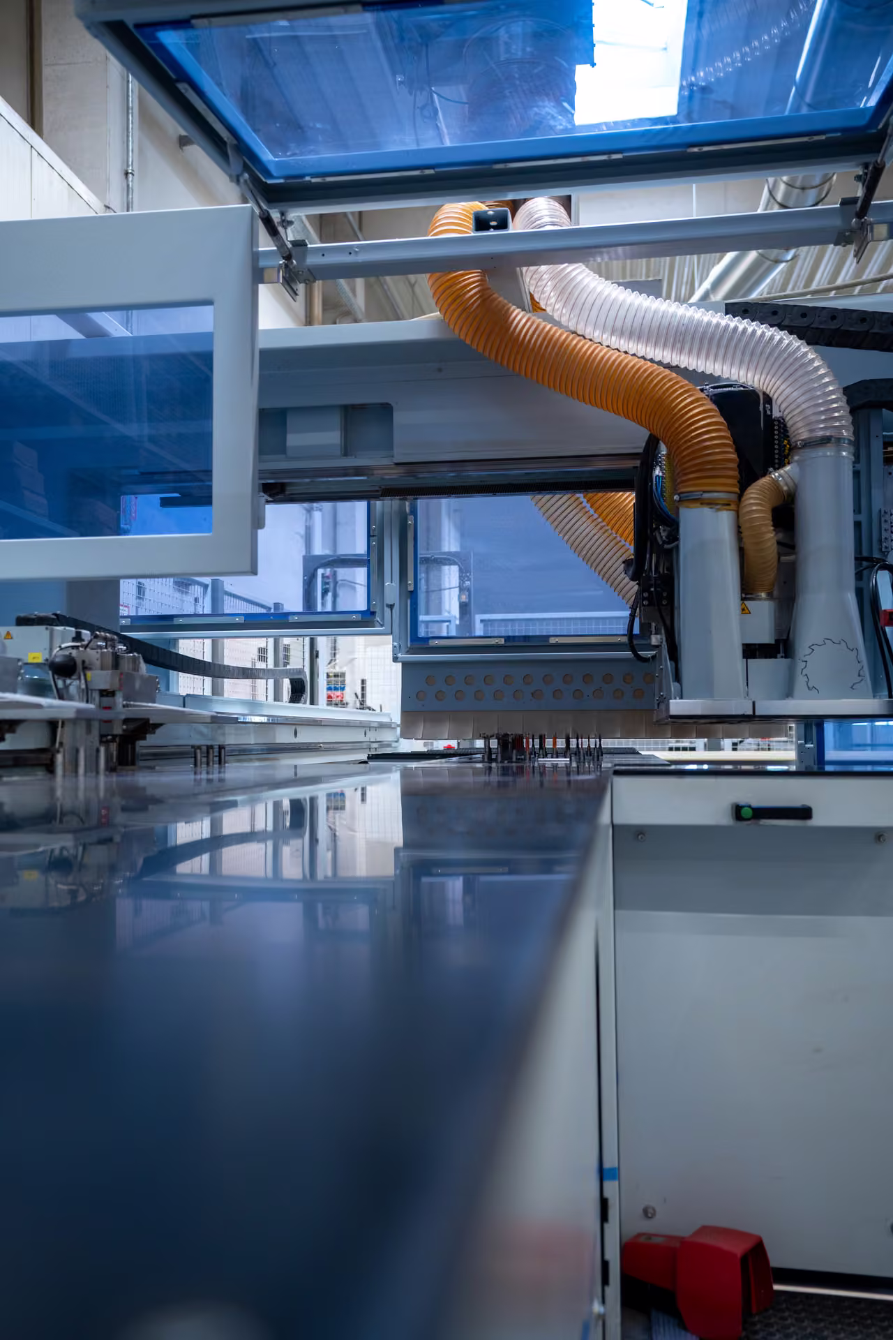 Werkzeugmagazin einer CNC-Maschine mit aufgereihten Fräswerkzeugen, darüber die Absaugung.