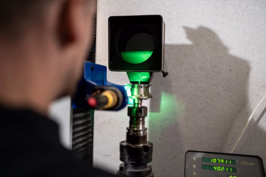 Messgerät mit grünem Licht vermisst ein eingespanntes Fräswerkzeug, ein Display zeigt Messwerte.