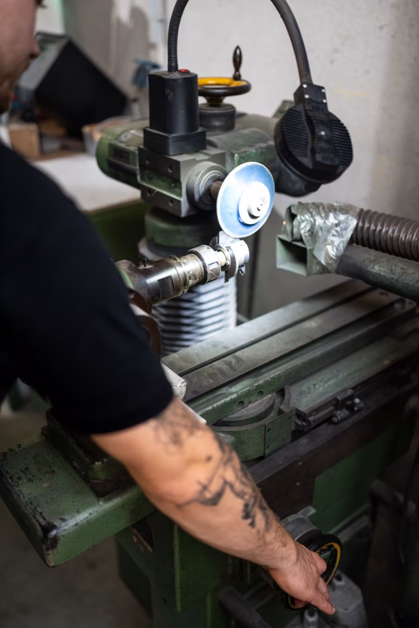 Mitarbeiter arbeitet an einer grünen Vorrichtung mit Handrad zur Werkzeugeinstellung.