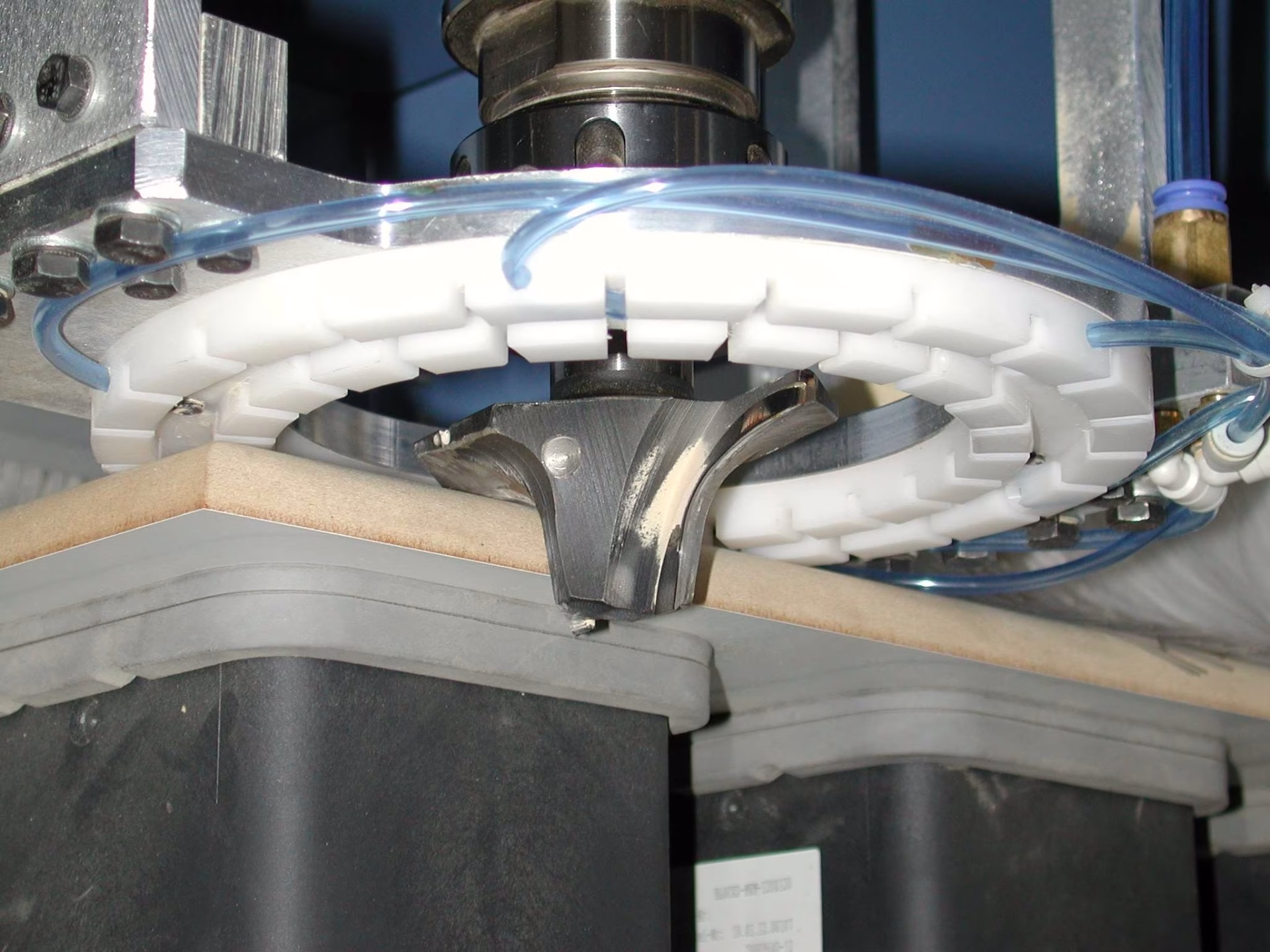 Fräsaggregat mit transparenter Absaughaube über einem Werkstück an einer CNC-Fräse.
